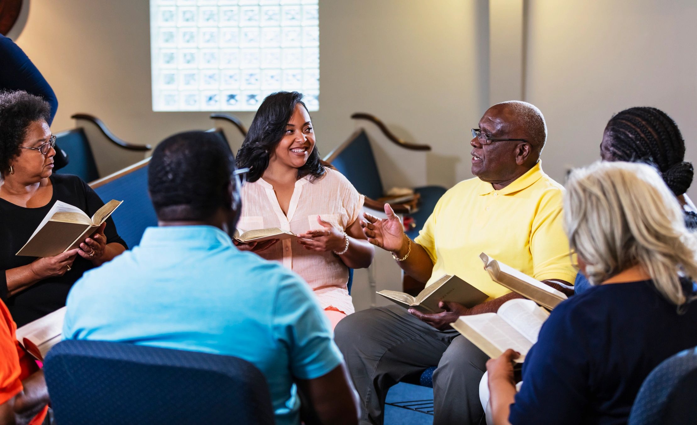 Bible study group gathered with open Bibles in discussion