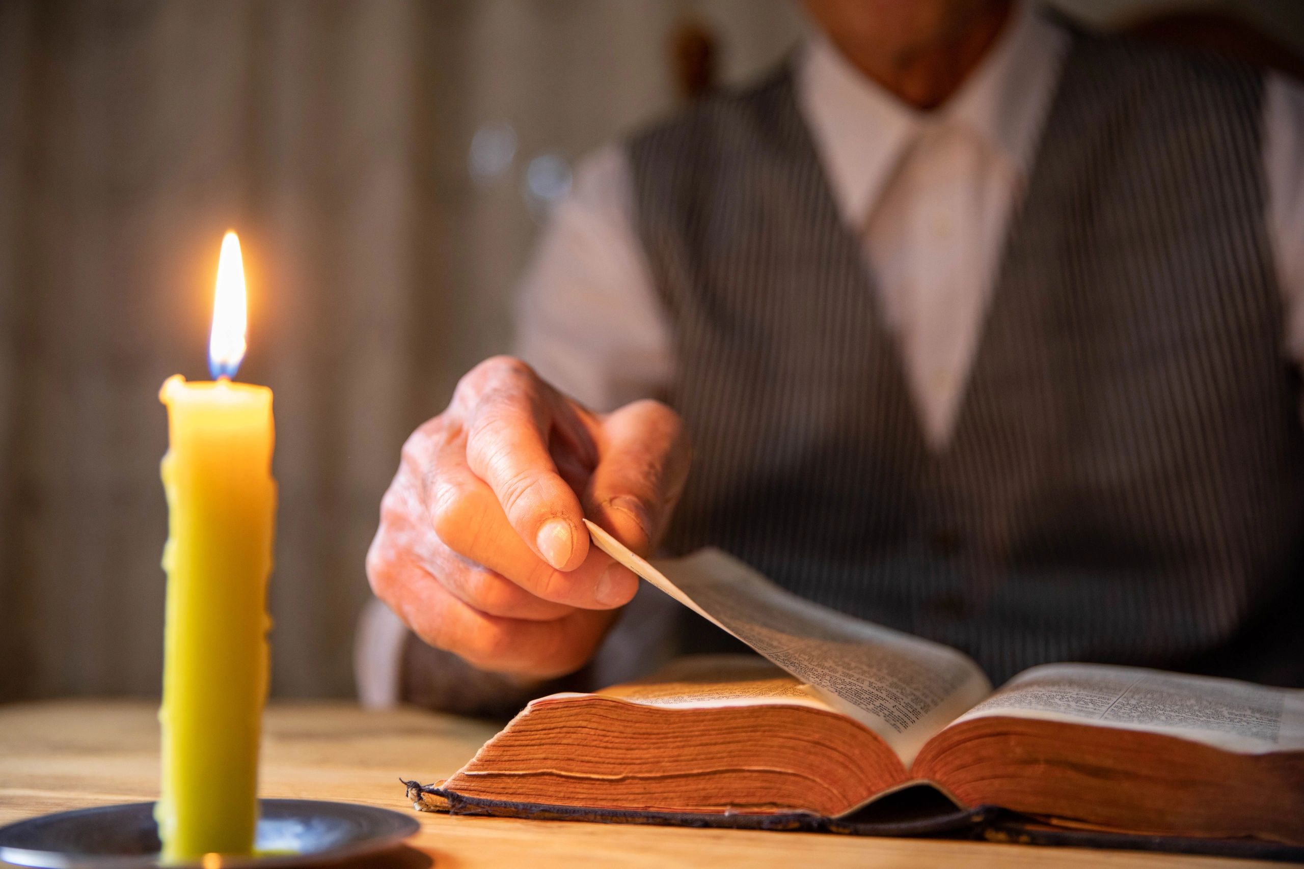 Candlelight beside an old Bible