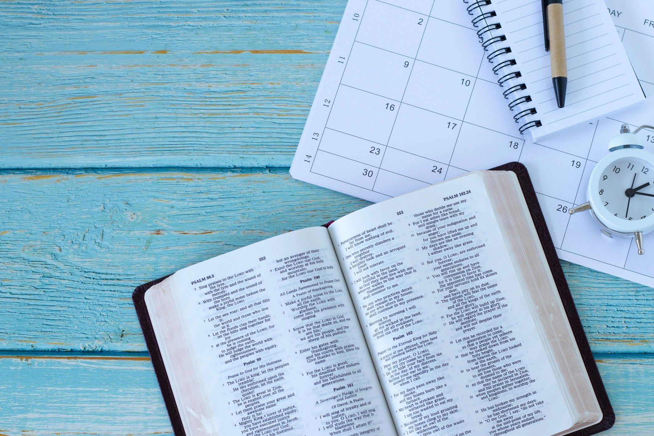 Open Bible with notebook and study materials on a table